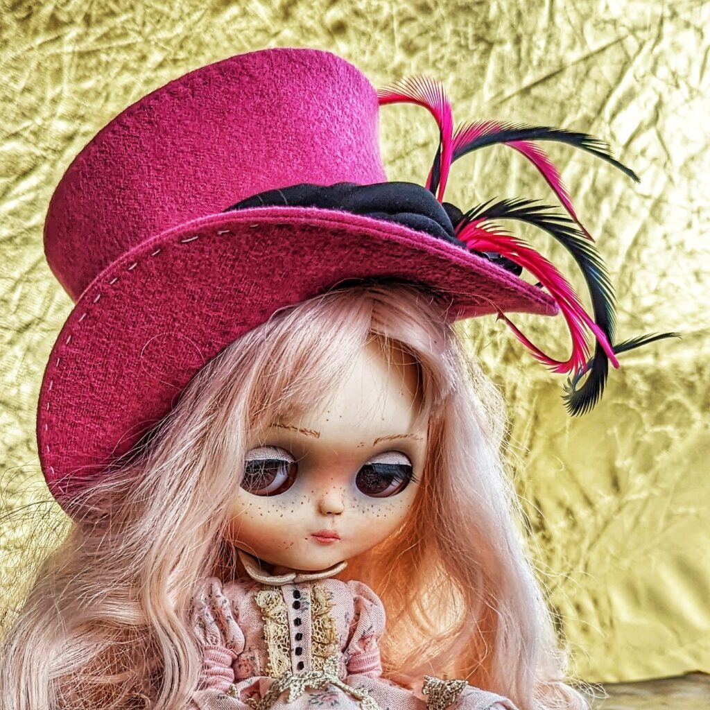 Blythe wearing a pink top hat 